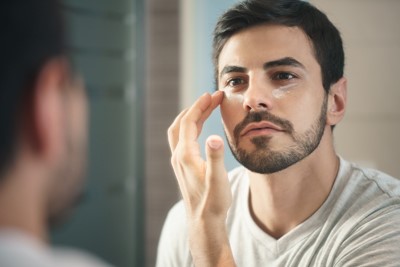 Picture of a man applying a skin care product with silicones