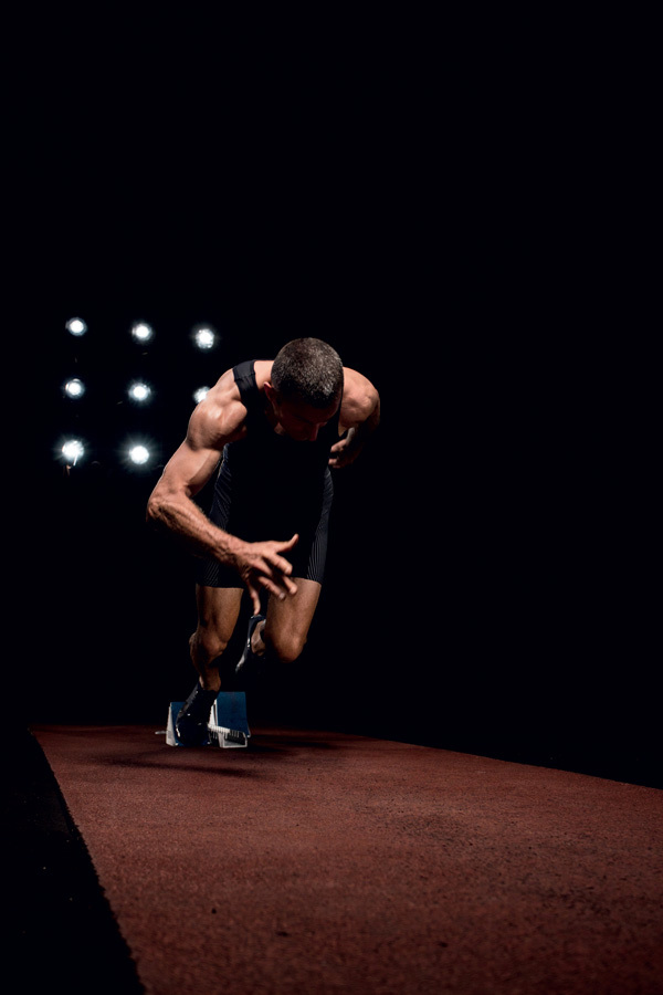 Athlete running on track in night